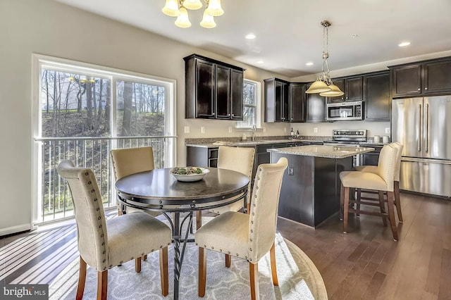 dining space featuring a notable chandelier, dark hardwood / wood-style floors, and sink