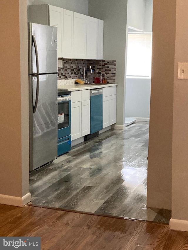 kitchen with tasteful backsplash, stainless steel appliances, dark hardwood / wood-style floors, and white cabinetry