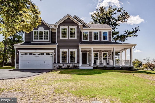 view of front of property with a porch, a front yard, and a garage