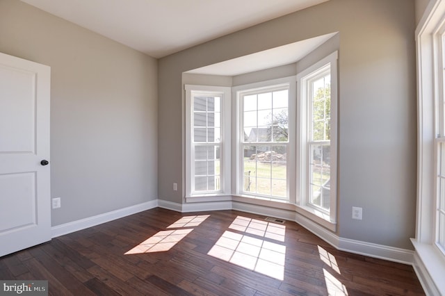 unfurnished room with dark wood-type flooring