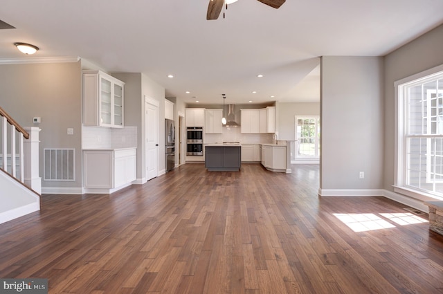 unfurnished living room featuring dark hardwood / wood-style flooring and ceiling fan