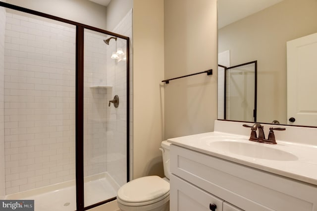 bathroom with vanity, toilet, and a shower with shower door