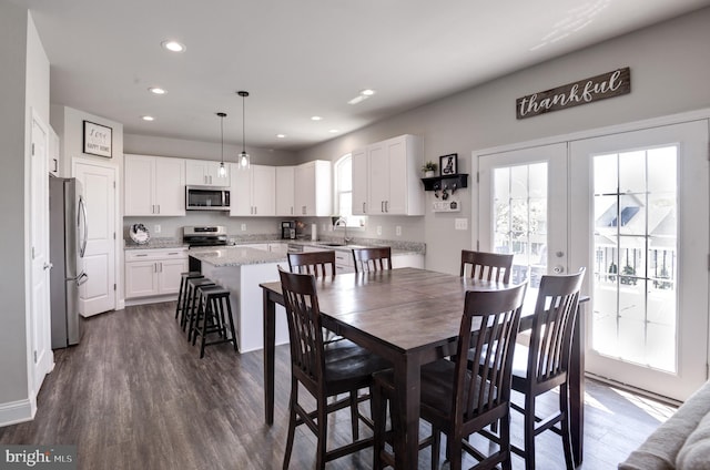 dining room with sink, dark wood-type flooring, and french doors