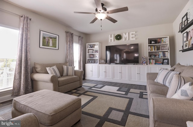 living room featuring dark hardwood / wood-style floors, built in features, plenty of natural light, and ceiling fan