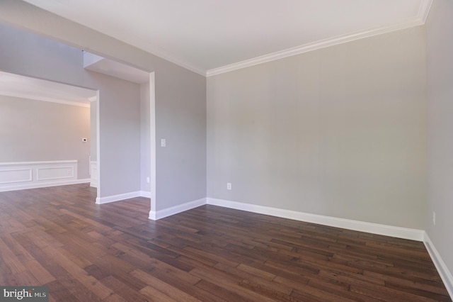 spare room featuring dark hardwood / wood-style flooring and crown molding