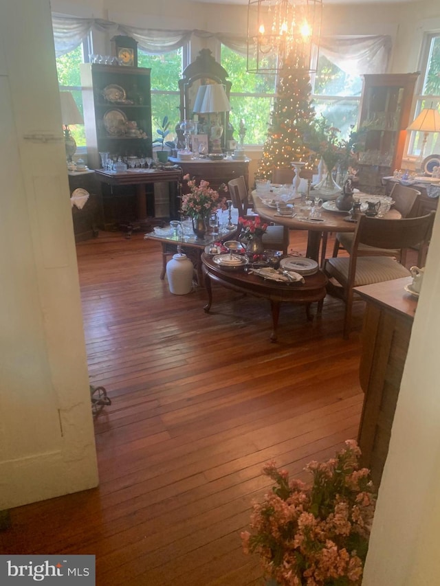 dining area featuring dark wood-type flooring, a wealth of natural light, and a chandelier