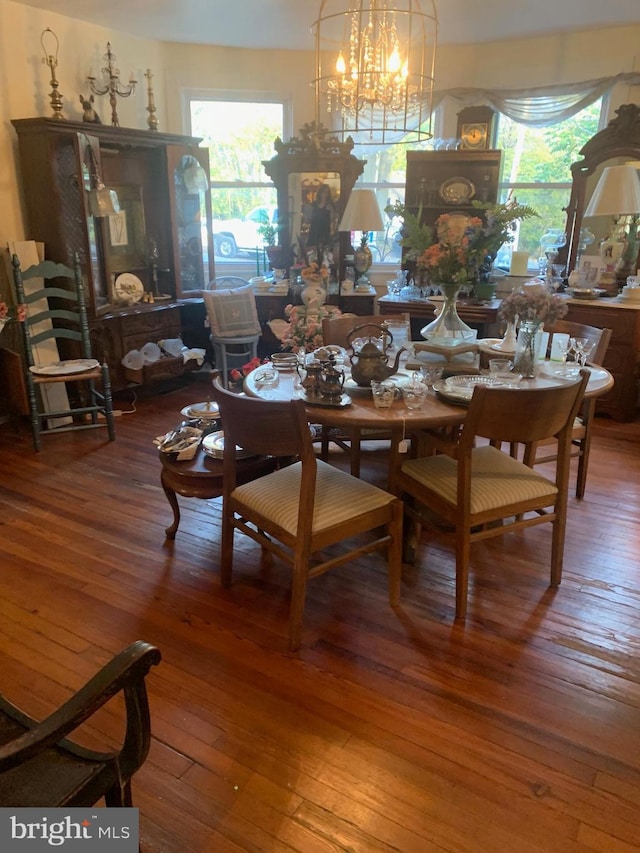 dining space featuring dark hardwood / wood-style flooring and an inviting chandelier