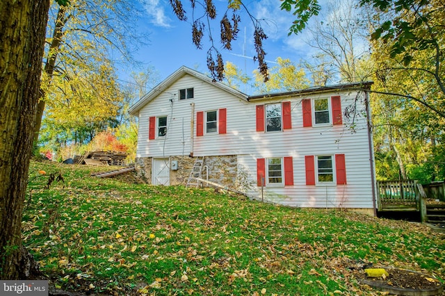 view of front of house with a wooden deck and a front lawn