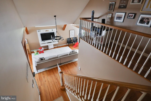 stairs featuring an inviting chandelier and light hardwood / wood-style flooring