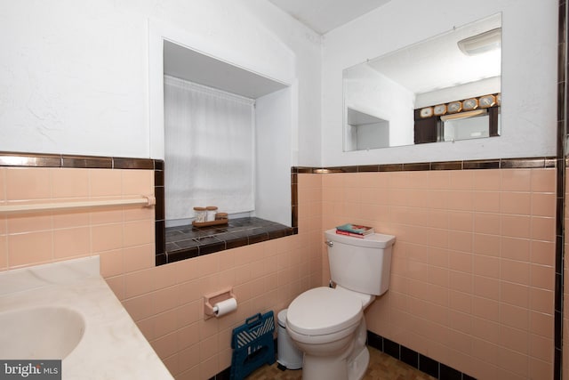 bathroom featuring tile flooring, tile walls, toilet, and vanity