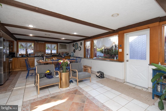 kitchen with a textured ceiling, a healthy amount of sunlight, and light tile floors