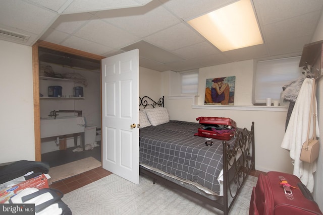 bedroom with carpet flooring and a drop ceiling