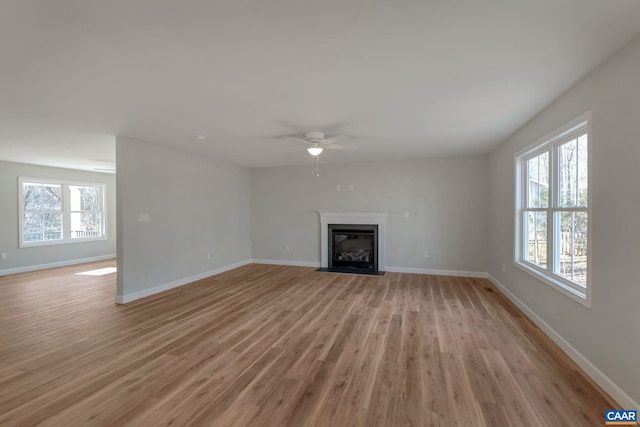 unfurnished living room with ceiling fan, light hardwood / wood-style floors, and a healthy amount of sunlight