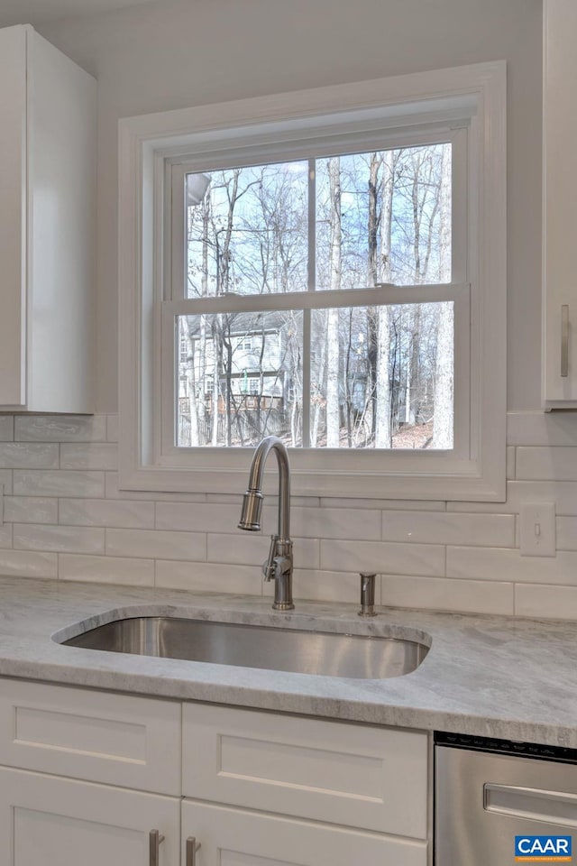 kitchen with sink, white cabinets, tasteful backsplash, and a wealth of natural light