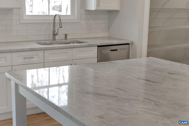 kitchen featuring white cabinets, light hardwood / wood-style flooring, sink, and light stone countertops