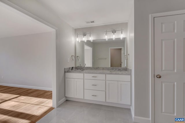 bathroom featuring dual sinks, oversized vanity, and tile flooring