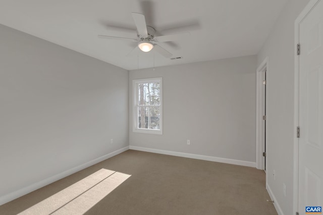 empty room with dark colored carpet and ceiling fan