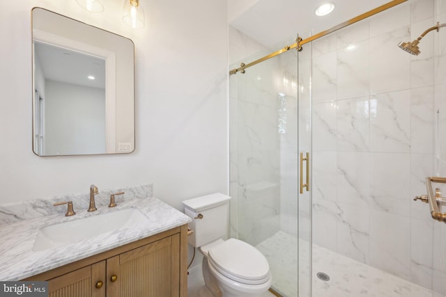 bathroom featuring vanity, toilet, and a shower with door