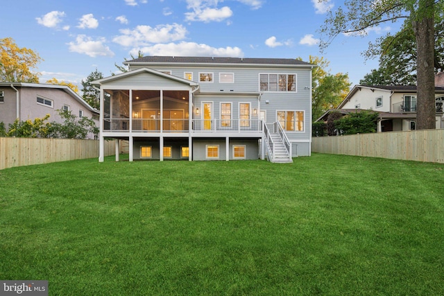 back of house featuring a yard, a sunroom, and a deck