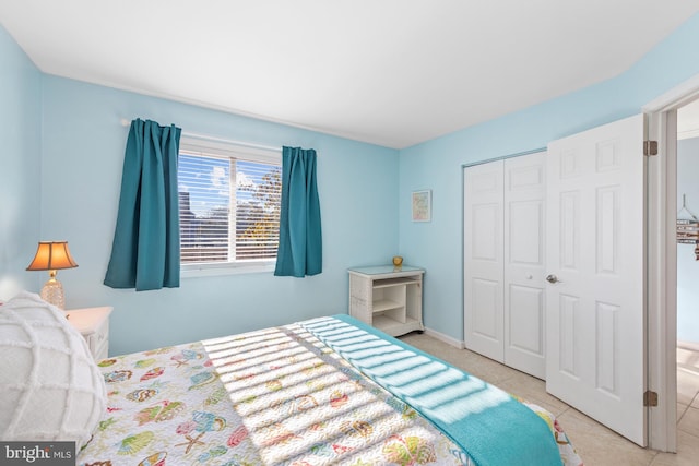 bedroom with a closet and light tile floors