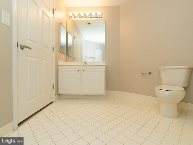 bathroom featuring tile flooring, toilet, and vanity