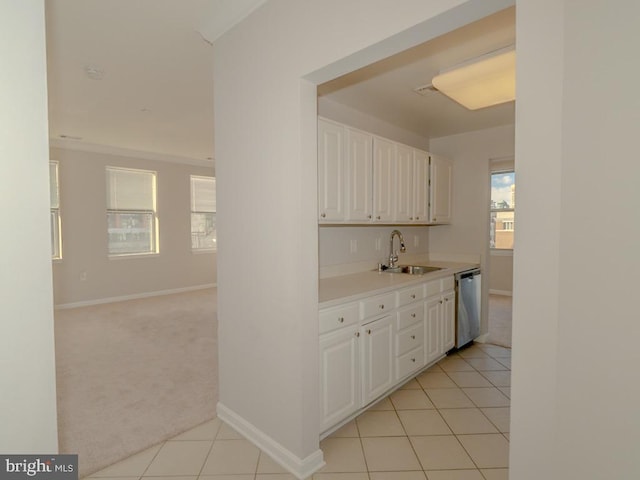 kitchen featuring sink, light tile flooring, white cabinets, and dishwasher