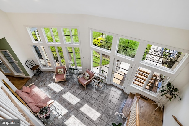 living room featuring dark tile floors and high vaulted ceiling