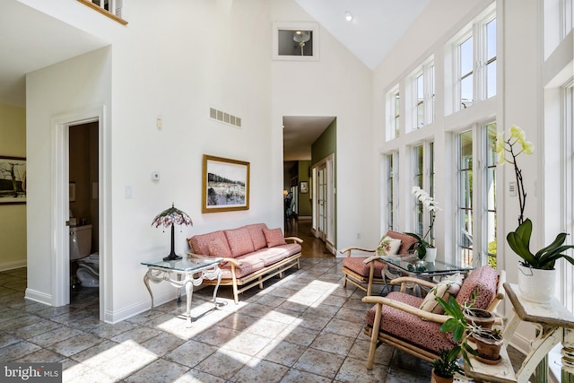 interior space with tile flooring and high vaulted ceiling