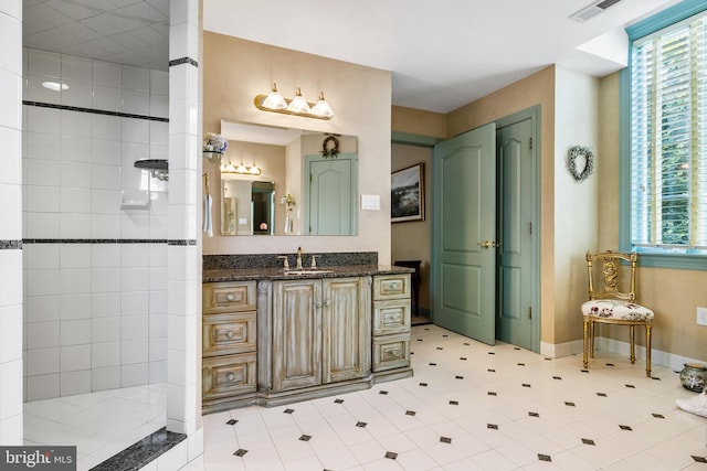 bathroom with tiled shower, tile floors, and vanity