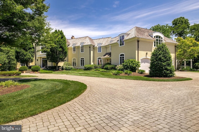 french country home featuring a front lawn