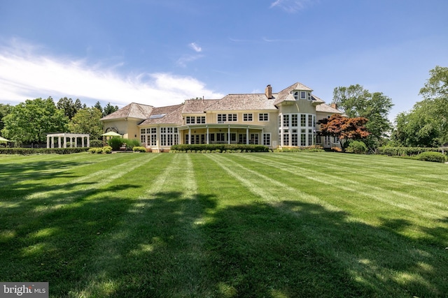 back of property with french doors and a lawn