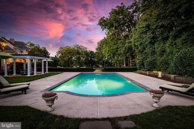 pool at dusk with a patio