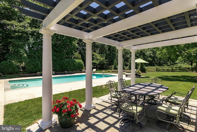 view of pool with a pergola, a patio area, and a lawn