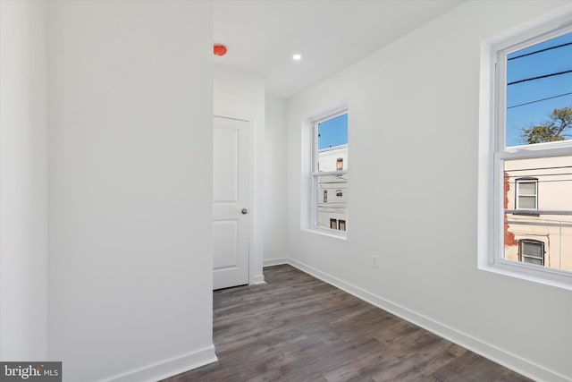 empty room featuring plenty of natural light and dark hardwood / wood-style floors