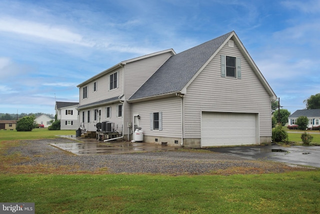 back of house with a yard, a garage, and central AC unit