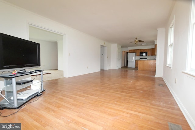 unfurnished living room with ceiling fan and light wood-type flooring