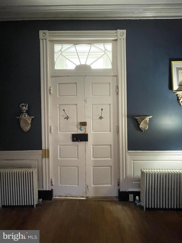 interior space featuring radiator heating unit, ornamental molding, and hardwood / wood-style floors