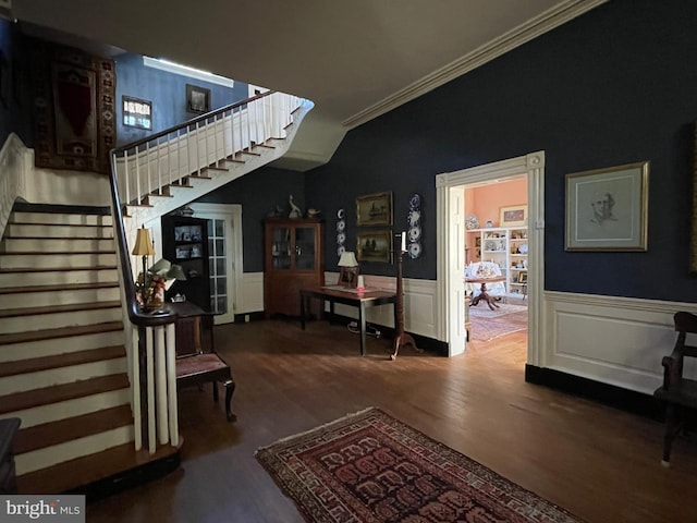 stairway with crown molding and wood-type flooring