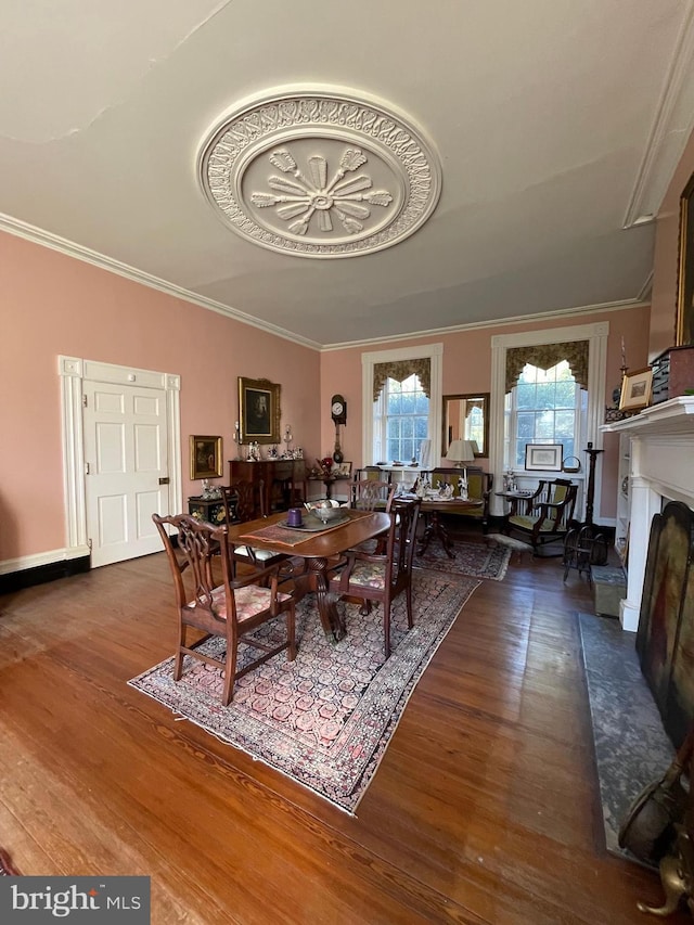 dining area featuring dark wood-type flooring and crown molding