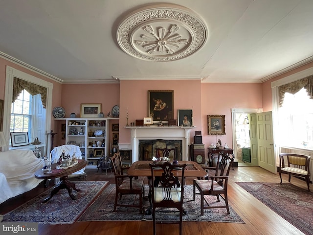 dining space featuring wood-type flooring and ornamental molding