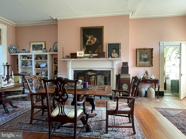 interior space featuring light wood-type flooring, ornamental molding, and a high end fireplace