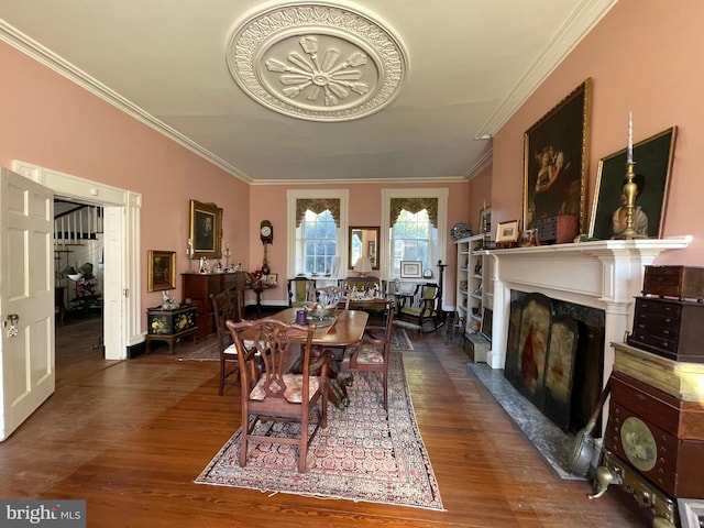 dining area featuring dark hardwood / wood-style flooring, a premium fireplace, and crown molding