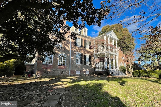 view of front of home with a front lawn and a balcony