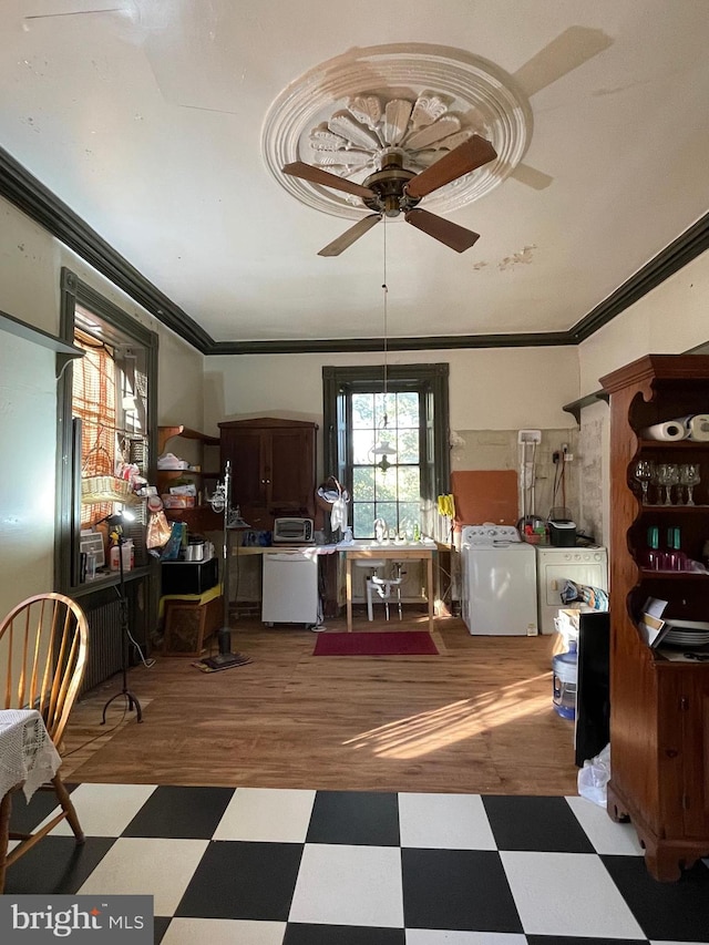 kitchen featuring ceiling fan, wood-type flooring, washing machine and clothes dryer, and ornamental molding