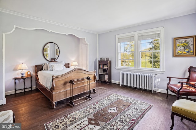 bedroom with radiator heating unit, ornamental molding, and dark wood-type flooring