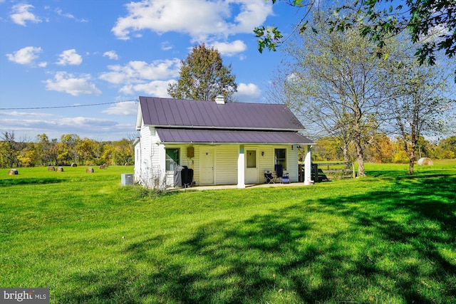 view of outdoor structure featuring a lawn, a porch, and central AC unit