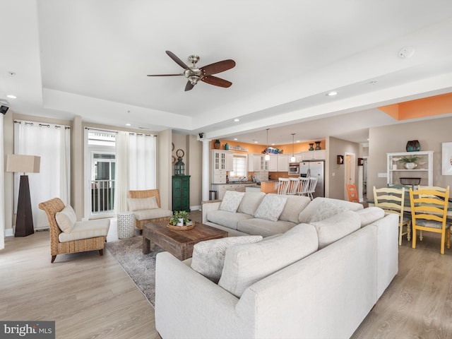 living room with ceiling fan and light hardwood / wood-style flooring