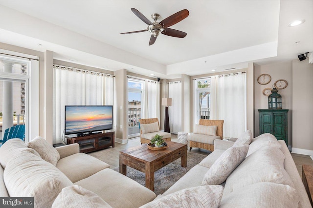 living room with ceiling fan and light hardwood / wood-style flooring