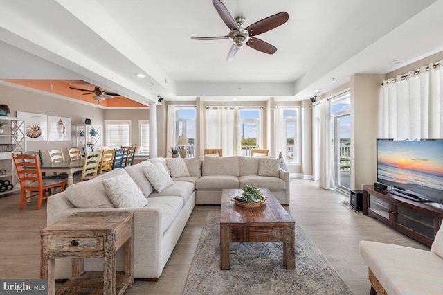 living room with ceiling fan and light hardwood / wood-style flooring