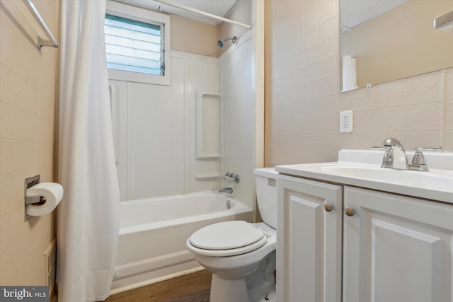 full bathroom with toilet, shower / bath combo, vanity, hardwood / wood-style floors, and tile walls